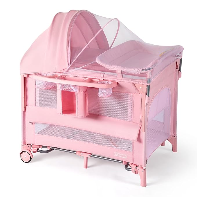 JOYMOR 9 in 1 Bedside Bassinet with Changing Table, Pack and Play with Bassinet, Convert to Rocking Baby Bed with Electric Music Center, Mosquito Net, Toy, Storage,Pink