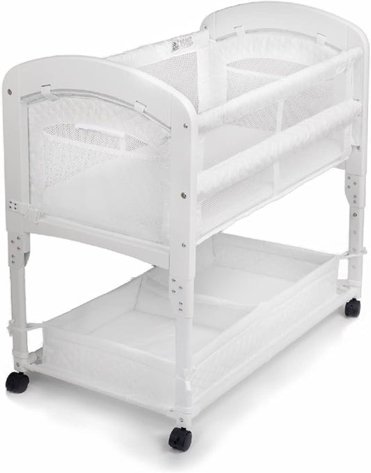 Arm’s Reach Cambria Co-Sleeper Bedside Bassinet Featuring Height-Adjustable Legs, Curved Wooden Ends, Breathable Mesh Sides with Pockets, and Large Lower Storage Basket, White