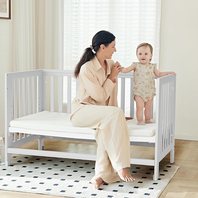 EvoNest Baby Crib, 6 in 1 Convertible Mini Crib with Wheels, 100% New Zealand Pinewood Growing Bed, 4 Adjustable Mattress Height， (Milk)