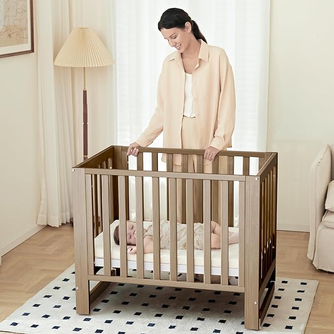 EvoNest Baby Crib, 6 in 1 Convertible Mini Crib with Wheels, 100% New Zealand Wood Growing Bed, 4 Adjustable Mattress Height，Walnut Brown